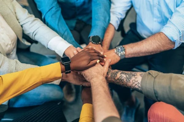 group of people joining hands